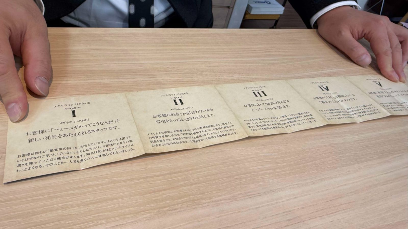 ▲スタッフ全員が身につけている「メガネのマエストロ5箇条」。金額に見合うメガネを提供するというビジョンメガネの行動指針がよりよいサービスに結びついている